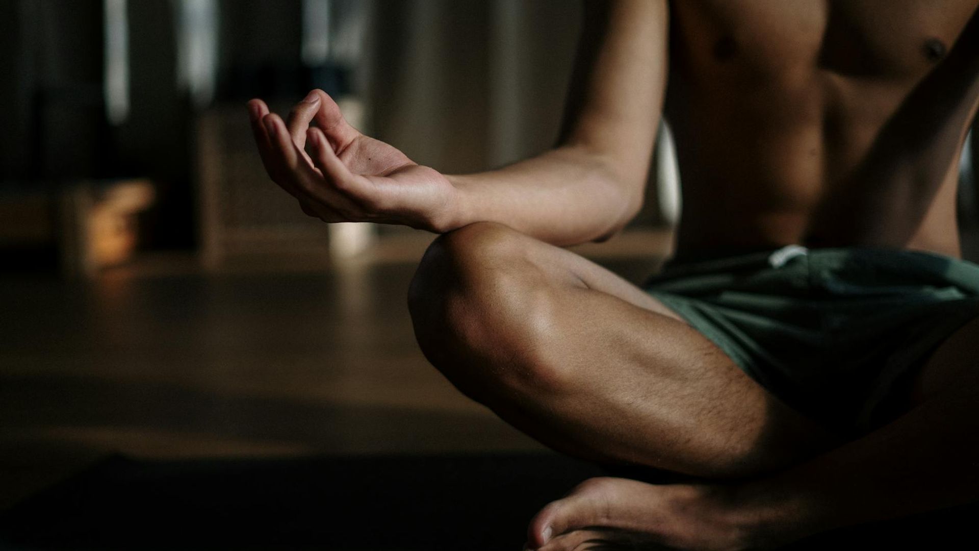 Person practicing yoga in a dark aesthetic studio.